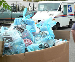 A letter carrier arrives at a distribution center to add to the enormous pile of expired canned and boxed goods donated for local hungry families. A letter carrier arrives at a distribution center to add to the enormous pile of expired canned and boxed goods donated for local hungry families.