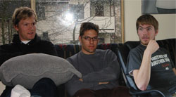 Mark Jones and Gabe Lamont lounge on the futon at Lamont's place as John Baxter explains his 